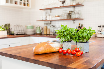 fresh bread,  basil and tomatoes on the wooden kitchen counter top