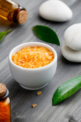 Close-up cosmetic orange sea salt on a wooden background.