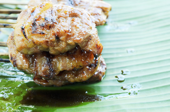Delicious thai grilled pork mooping local food on banana green leaf