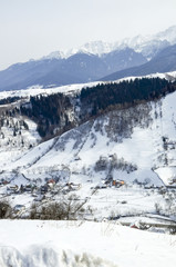 Fototapeta na wymiar Idyllic winter landscape with mountains, sunny day; Bran, Romania