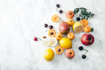 Naklejka na ściany i meble Summer fruits assorted on white marble background. Fresh raw food concept. Copy space