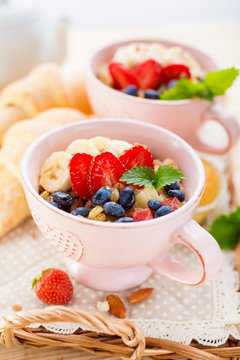 Porridge with banana and fresh berries in a cups.