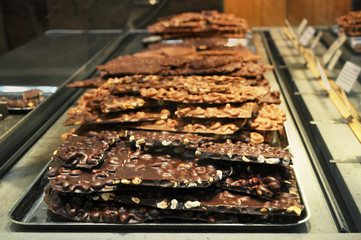 Pieces of chocolate with nuts on the counter of the grocery market.