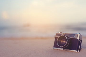 Vintage camera is located on the beach.