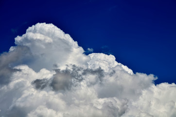 Fototapeta na wymiar Blue sky with white and gray cumulus clouds. Closeup