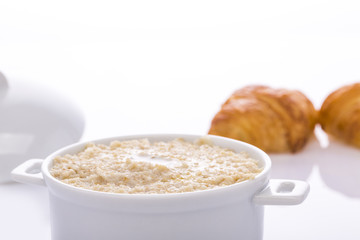 Oat porridge in a white saucepan. Oatmeal. Cap..