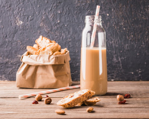 Fresh crispy traditional Italian cookies with coffee and milk drink on a wooden table