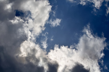 Blue sky with white and gray cumulus clouds. Closeup