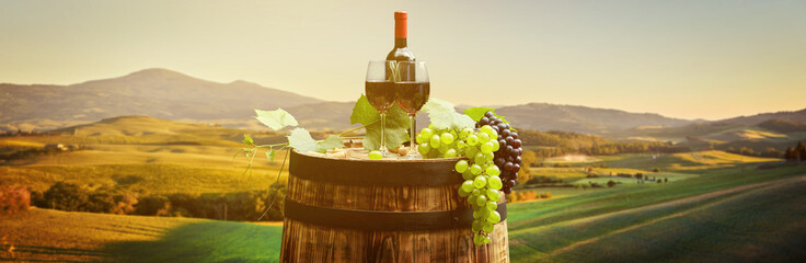 Red wine with barrel on vineyard in green Tuscany, Italy