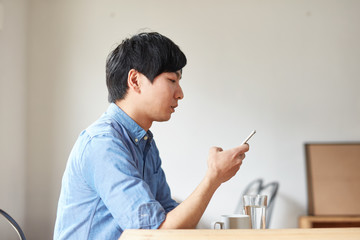 カフェで携帯電話を使う男性