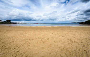 Fototapeta na wymiar Atlantic sandy beach in Spain with city of Coruna background.