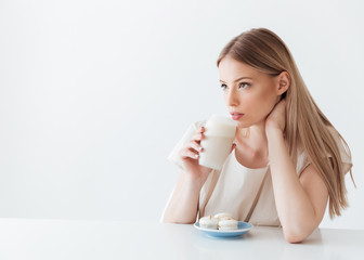 Lady sitting isolated near sweeties drinking coffee