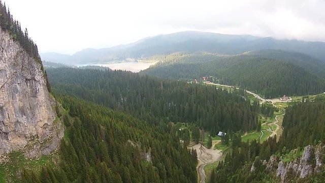 Zanoaga Gorge in Bucegi Natural Park , Carpathian Mountains, Romania , steep limestone cliffs , fir forests and alpine vegetation , with lake in the background , aerial view
