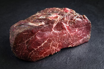 Dry aged raw Point Steak as close-up on a slate