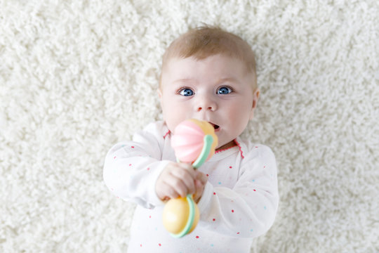 Cute Baby Girl Playing With Colorful Pastel Vintage Rattle Toy