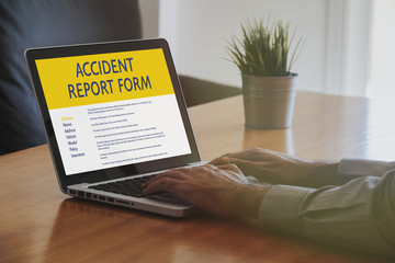 Man fill in an accident report form with a laptop by internet.