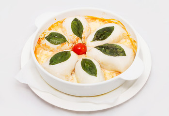 Stuffed sqiud on a white plate with green leaves