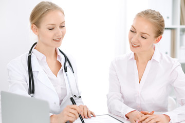 Doctor and  patient  sitting at the desk 