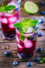 Blueberry ice lemonade with lime and mint in glasses