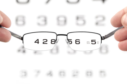 Glasses In Hands And Eye Test Chart
