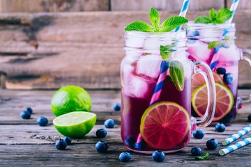 Blueberry ice mojito with lime and mint in mason jar