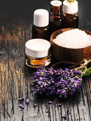 Fototapeta na wymiar Lavender spa , bunch of lavender flowers , essential oil and salton a black wooden background.