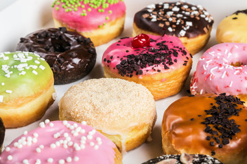 fresh assorted filled donuts in a box on the table
