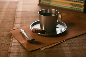 coffee Cup with spoon and biscuits on the background of notebooks
