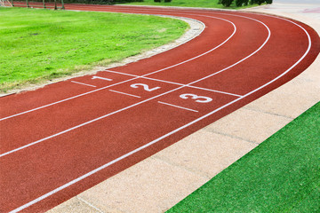 close up on detail of red track at start point running and curve line, sport background.