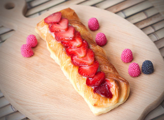 Dessert with strawberries and berry candies on a wooden board
