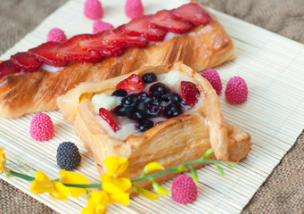 Pastries with berries on a wooden background. Summer fruit dessert
