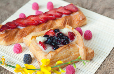 Pastries with berries on a wooden background. Summer fruit dessert