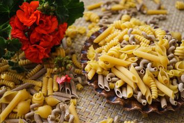 Pasta made from flour, scattered on a plate, on a table.