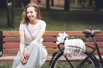 Woman sitting on wooden bench in park