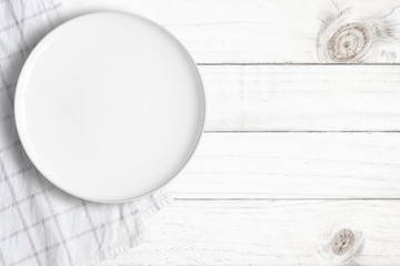 Top view of empty food plate put on tablecloth and wood table., All white object with copy space.