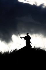 Silhouette black and white photo warrior with sword on the mountain