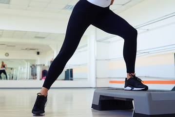 Cropped shot of skinny woman legs doing step aerobics
