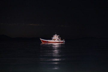 A boat on the sea at night - Powered by Adobe