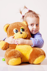 Beautiful baby girl playing with a teddy bear (Childhood, joy, serenity)