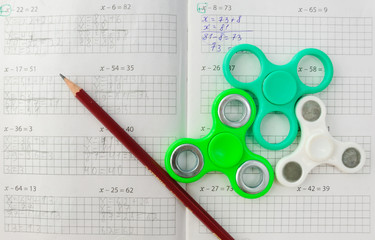 Fidget spinner stress relieving toy on notebook background