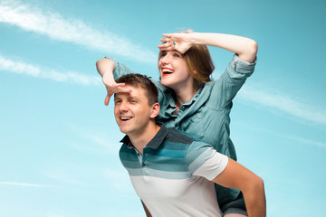Young couple smiling under blue sky