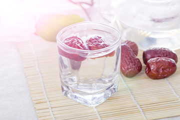 A glass cup of Chinese red date tea on the table. Chinese red dates are believed to be a nutritional supplement that helps promote production of red blood cells.