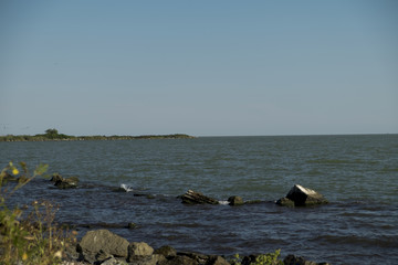 Peaceful landscape with waterline and rocks, at the Black Sea shore, Romania, sunny day, blue sky with clouds