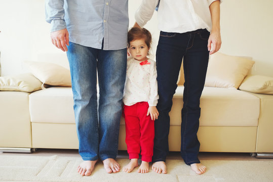 Girl Hugging Mom And Dad For Legs