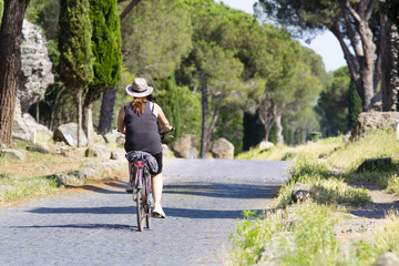 donna in bicicletta nel parco archeologico dell'Appia Antica