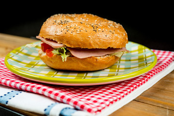 Bagel with fresh cheese and fresh lettuce on napkin
