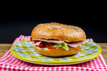 Bagel with fresh cheese and fresh lettuce on napkin