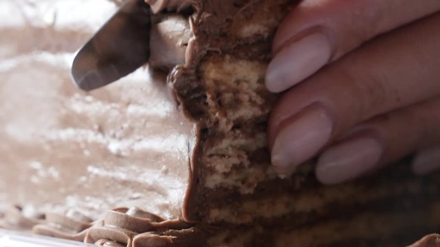 Close-up knife using for chocolate cake 4K 2160p 30fps UltraHD footage - Cutting on pieces multilayered torte with biscuits 3840X2160 UHD video