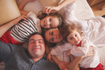 young family lying in bed at home