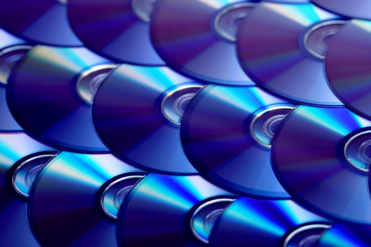 Compact discs background. Several cd dvd blu-ray discs. Optical recordable or rewritable digital data storage.